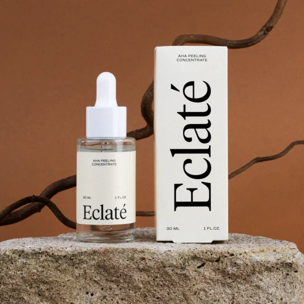 Eclaté-branded facial serum dropper bottle and box displayed on a wooden surface with twine.