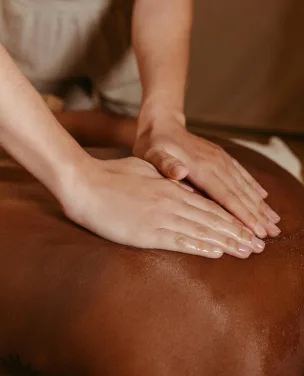 Close-up of hands giving a back massage during a spa treatment.
