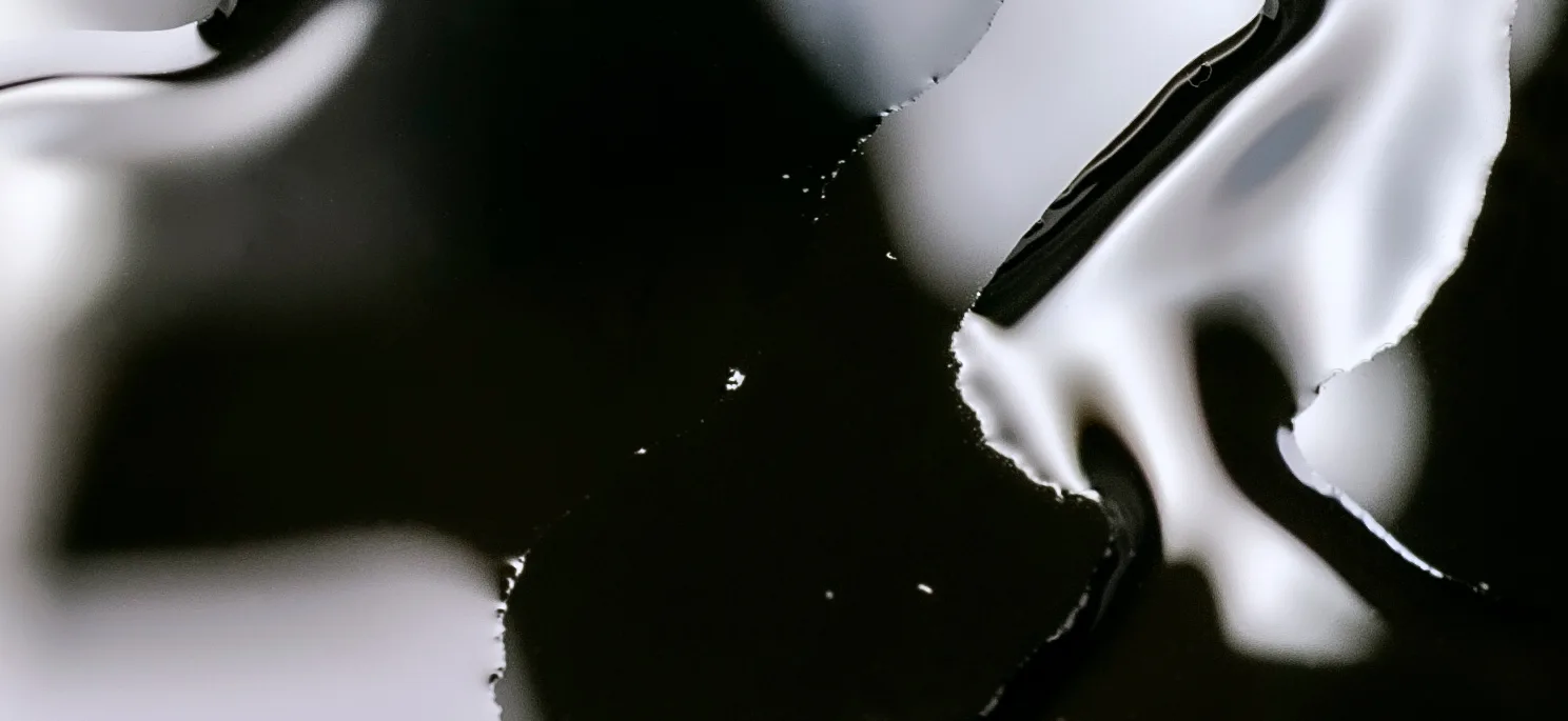 Abstract close-up of glossy black-and-white marbled liquid, used as a dark background for the Selfnamed Pro banner.